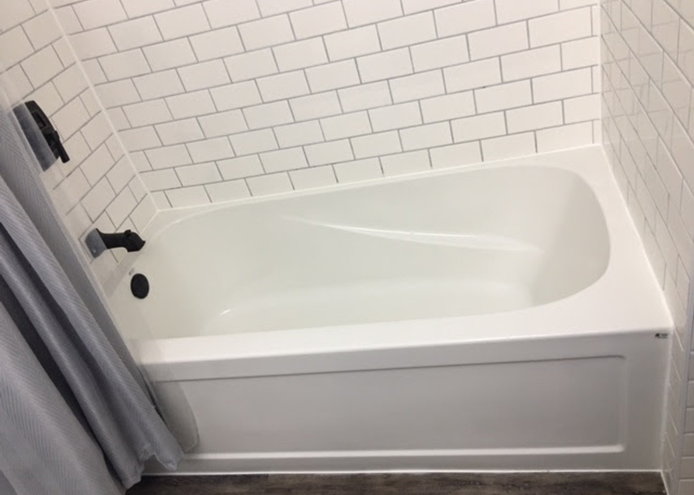 Tiled tub surround with subway tile and matte black fixtures