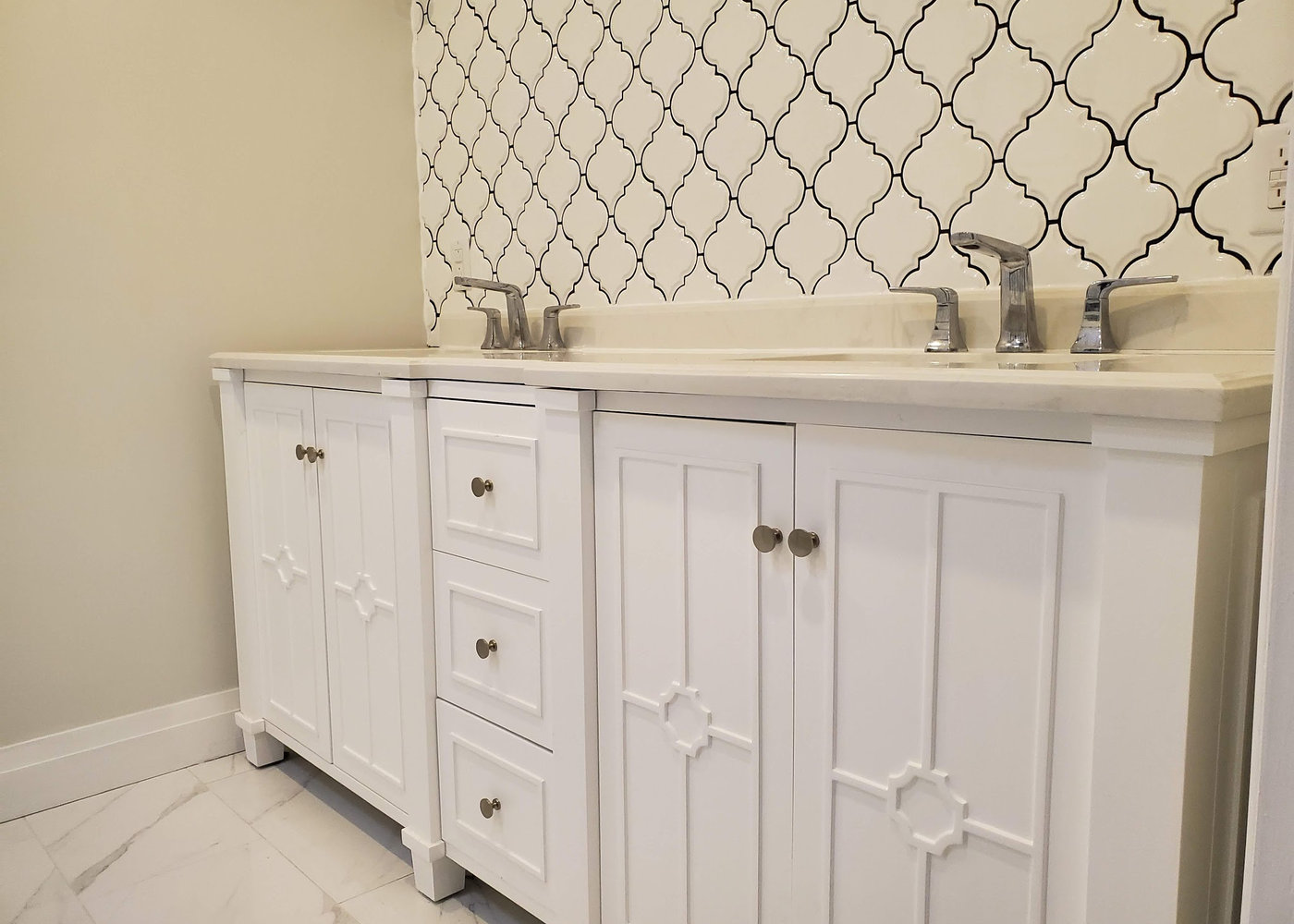 Double vanity with quartz counter and patterned tile backsplash