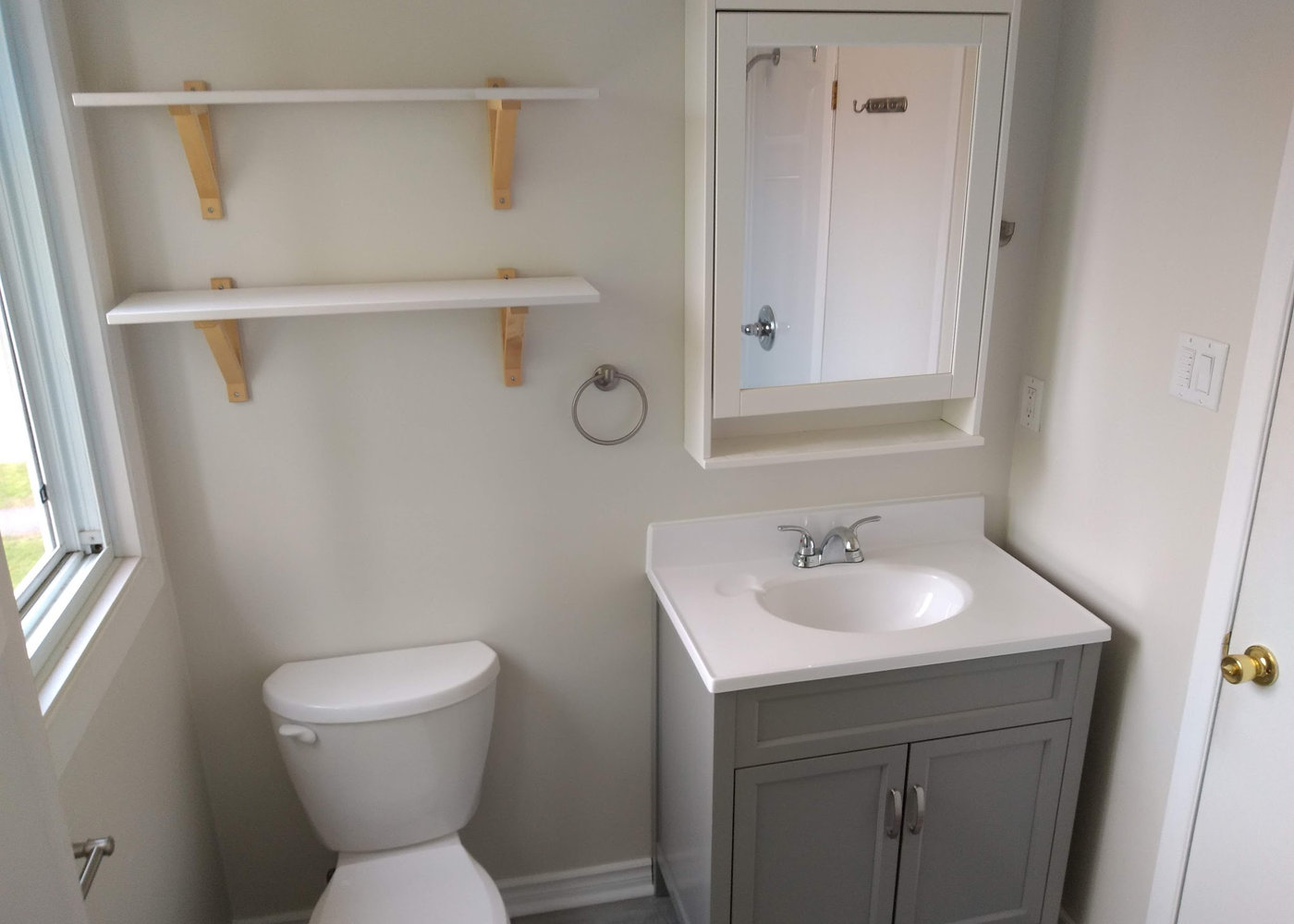 Compact powder room with new vanity and open shelving
